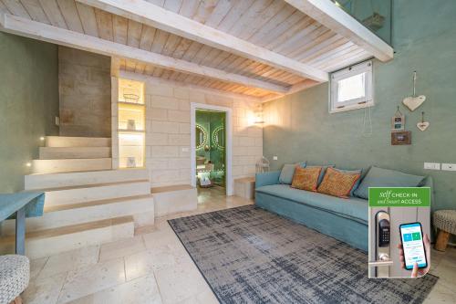 a living room with a blue couch and stairs at Corte Dei Granai Meeting & SPA - Raro Rooms Collection in Maglie