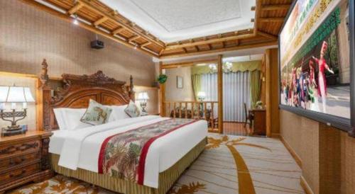 a bedroom with a large bed and a flat screen tv at Hangzhou The First World Hotel in Hangzhou