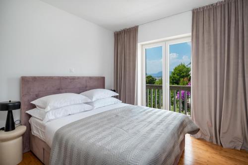 a bedroom with a bed and a large window at Marevita in Podstrana