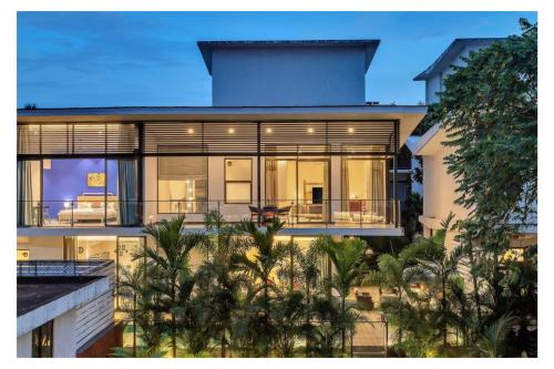 an exterior view of a building with palm trees at Dia Hotels and Homes Nerul Goa - Villas and Apartments in Nerul