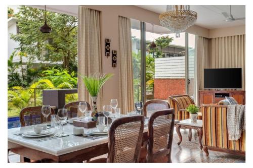 a dining room with a table with wine glasses at Dia Hotels and Homes Nerul Goa - Villas and Apartments in Nerul