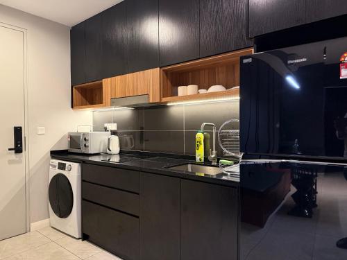 a kitchen with a sink and a dishwasher at Axon Suite Bukit Bintang By Luna in Kuala Lumpur