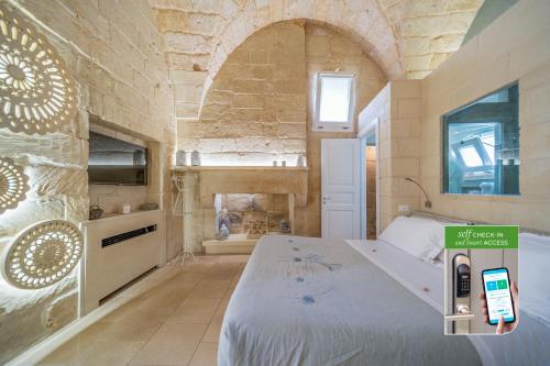 a bedroom with a bed with a cell phone on it at Corte Dei Granai Meeting & SPA - Raro Rooms Collection in Maglie