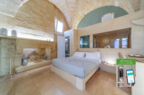 a bedroom with a bed and a cell phone in it at Corte Dei Granai Meeting & SPA - Raro Rooms Collection in Maglie