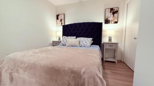a bedroom with a large bed with a blue headboard at One Lux Stay - Hollywood in Los Angeles