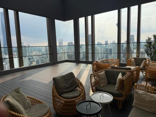 a balcony with chairs and tables on the top of a building at Axon Suite Bukit Bintang By Luna in Kuala Lumpur