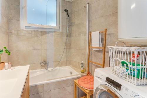 une salle de bain avec baignoire et machine à laver dans l'établissement LE PAIROLIERE AP4461 by Riviera Holiday Homes, à Nice