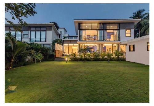 a large house with a lawn in front of it at Dia Hotels and Homes Nerul Goa - Villas and Apartments in Nerul