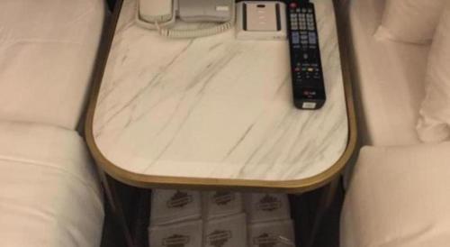a small table with a remote control on it next to a bed at King's Hotel in Hong Kong