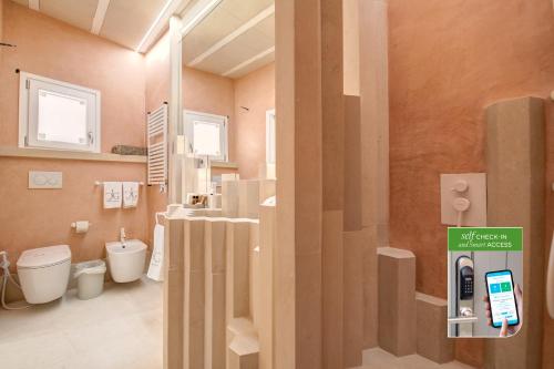 a bathroom with a toilet and a phone on a door at Corte Dei Granai Meeting & SPA - Raro Rooms Collection in Maglie