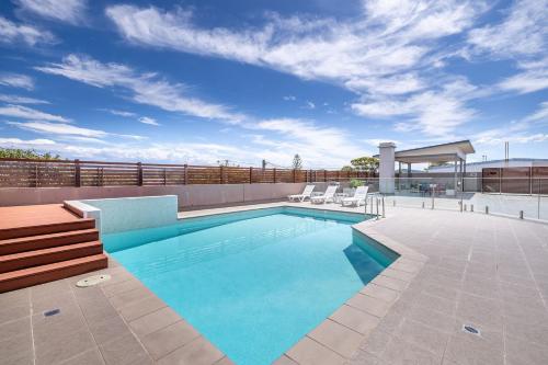 a swimming pool on top of a building at Barefoot Bliss 4, 6-10 Market Street - Surfside Apartments in Fingal Bay