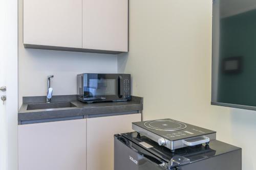 a kitchen with a microwave and a sink at CityZen - Boutique Studios in Achrafieh in Beirut