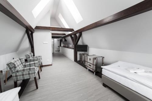 a bedroom with a bed and chairs in a room at Apartamenty NEPTUN in Poznań