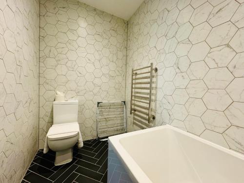 a bathroom with a toilet and a bath tub at First Avenue Apartments in Moffat