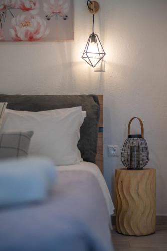 a bedroom with a bed with a lamp and a basket on a table at SKYROS AVRA Residences in Skiros