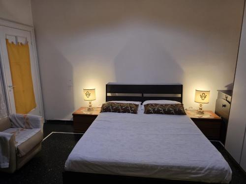 a bedroom with a large bed with two lamps on tables at Room PR Casa Solari in Genova