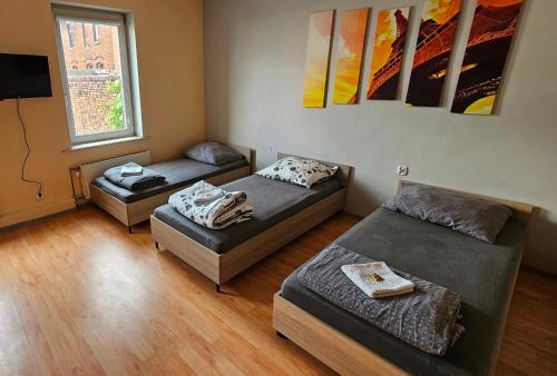 a room with two beds and a tv in it at Apartamenty Piekary in Piekary Śląskie
