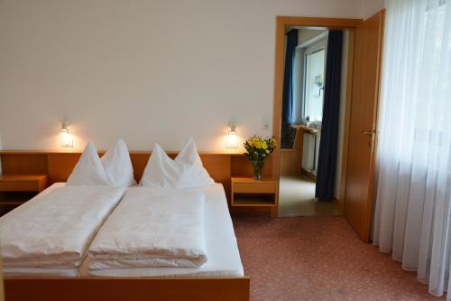 um quarto com uma cama branca e almofadas brancas em Residence Feldhof em Castelbello