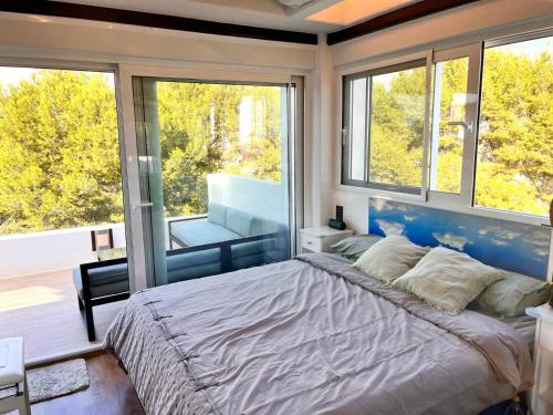 a bedroom with a large bed and large windows at CHALET MÁGICO en Orihuela Costa in Los Dolses