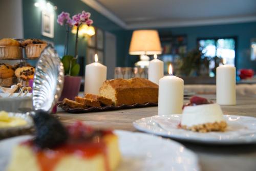 a table topped with plates of food and candles at Hotel Villa Linneo in Rome