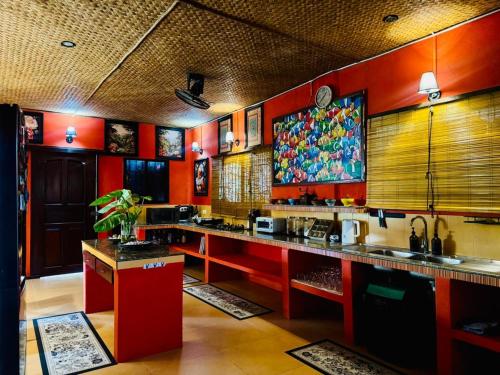 a kitchen with red walls and a large counter at Casa Manalo Guest House in Puerto Princesa City