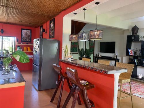 a kitchen with a red wall with a refrigerator at Casa Manalo Guest House in Puerto Princesa City