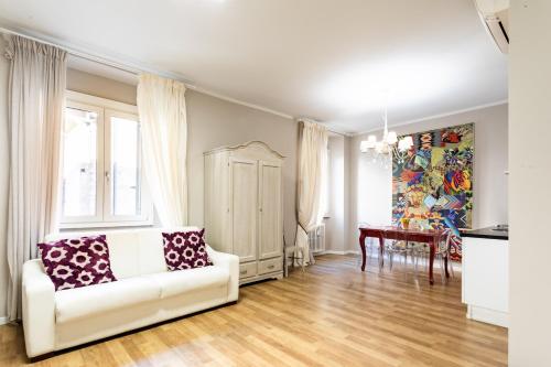 Una sala de estar con un sofá blanco y una mesa. en Suite Santa Eufemia 2 - VICINO ARENA, en Verona