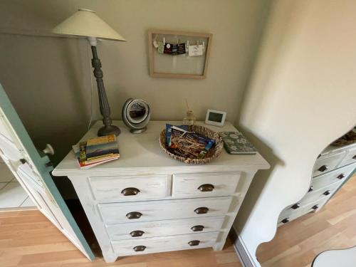 a white dresser with a lamp on top of it at Maison aux pieds des volcans in Orcines
