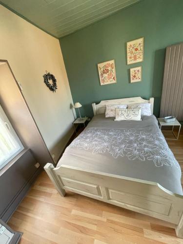 a bed in a bedroom with green walls at Maison aux pieds des volcans in Orcines