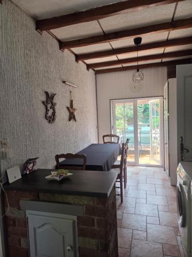 a room with a bed and a kitchen with a table at LA PARENTHÈSE AU PAYS DU VERT in Soucht