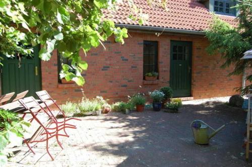 a yard with a brick house with a green door at Ferienwohnungen Meyer in Bollewick