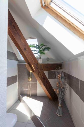 une salle de bains mansardée avec une lucarne et des toilettes. dans l'établissement Cabana & Clos des Epinoches, à Mâcon