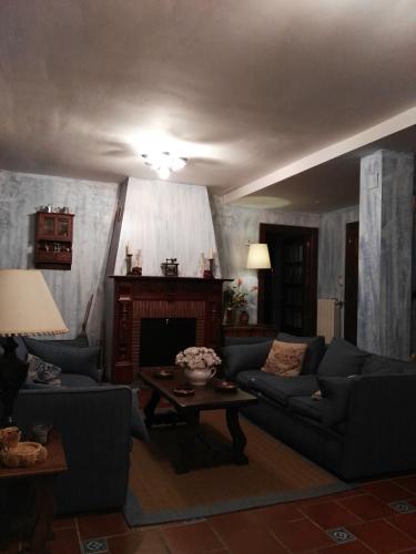 a living room with two couches and a fireplace at Posada Valle De Guriezo in Ríoseco