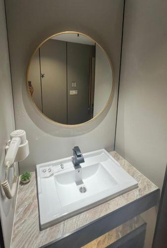 a bathroom with a sink and a mirror at Extreme Boutique Hotel in Kluang