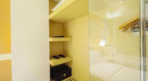 a small room with a shower and a bed at Brits Hotel Karawang in Karawang