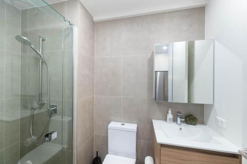 a bathroom with a shower and a toilet and a sink at 1BR Alpha APT - Central Stay Top Amenities in Wellington