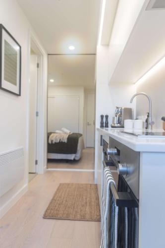 a kitchen with a sink and a bathroom with a bed at 1BR Alpha APT - Central Stay Top Amenities in Wellington