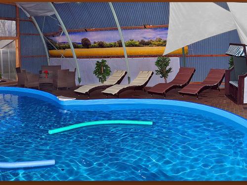 a swimming pool with lounge chairs and a swimming pool at Ferienwohnung Galerie 2 in Niedersachsen-Stadland