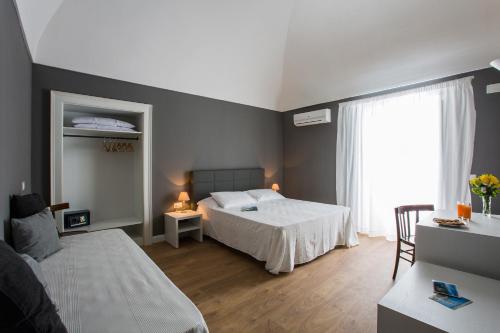 1 dormitorio con cama blanca y ventana en B&B In Centro, en Vieste