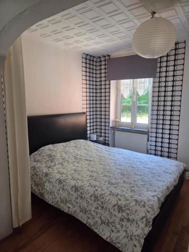 a bedroom with a bed and a large window at LA PARENTHÈSE AU PAYS DU VERT in Soucht