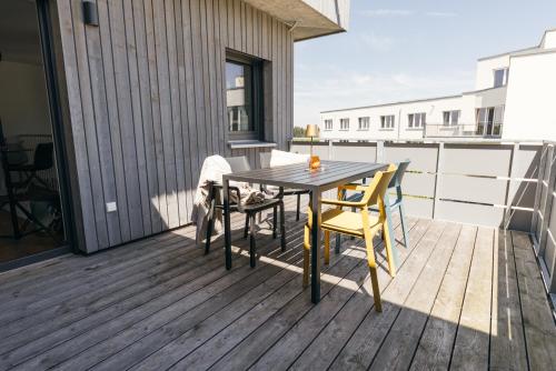 a wooden deck with a table and chairs on a balcony at HEIMATEL - Bodensee Residenz Allgäu in Scheidegg