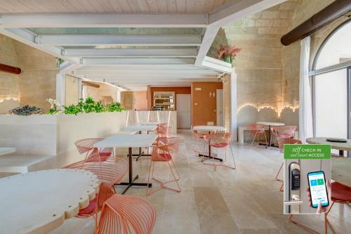 a restaurant with tables and chairs in a room at Corte Dei Granai Meeting & SPA - Raro Rooms Collection in Maglie