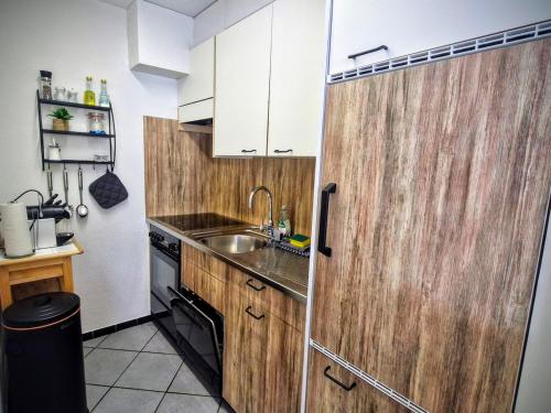 a small kitchen with a sink and a wooden door at Apart Weisshorn WHG 122 Valère B in Leukerbad