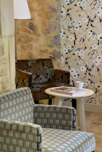 a living room with a table and a chair and a coffee table at La Maison de Mathilde in Bayeux