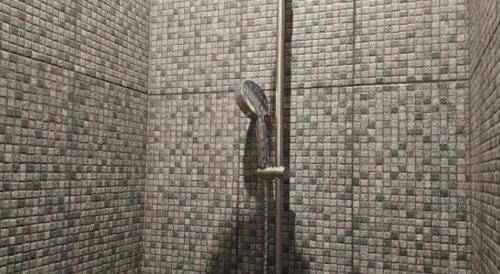a shower in a brick wall with a clock at The Buffalo Amphawa in Samut Songkhram