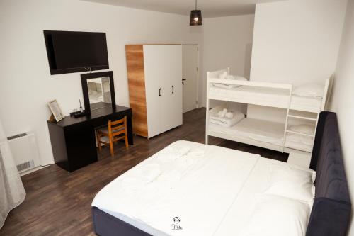 a bedroom with a bed and a desk and a television at Hotel & Restaurant Frida in Gjakove
