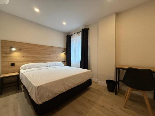 a bedroom with a bed and a desk and a chair at CC Gijon in Gijón