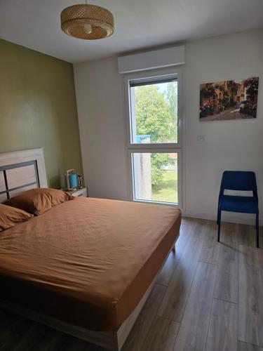 a bedroom with a bed and a chair and a window at Appartement cosy proche Sceneo, Auchan, Saint-Omer in Longuenesse