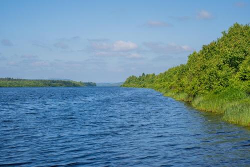 a large body of water with trees on either side at Nova Galaxy Village in Rovaniemi