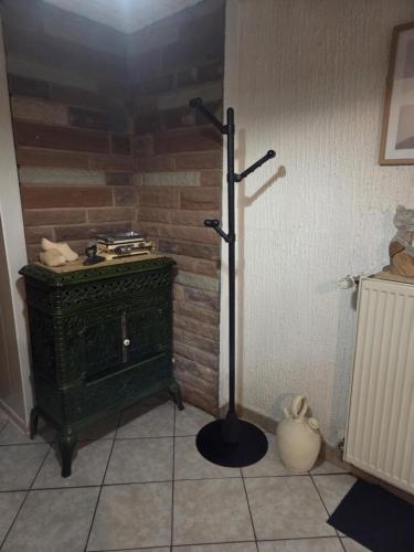 a room with a green stove in a corner at LA PARENTHÈSE AU PAYS DU VERT in Soucht